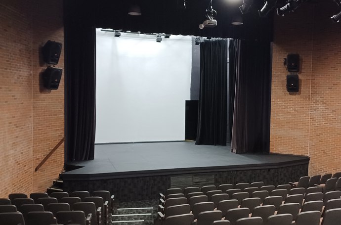 An empty theatre stage with rows of seats