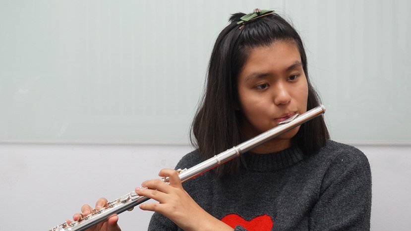 Young teenage girl playing the flute