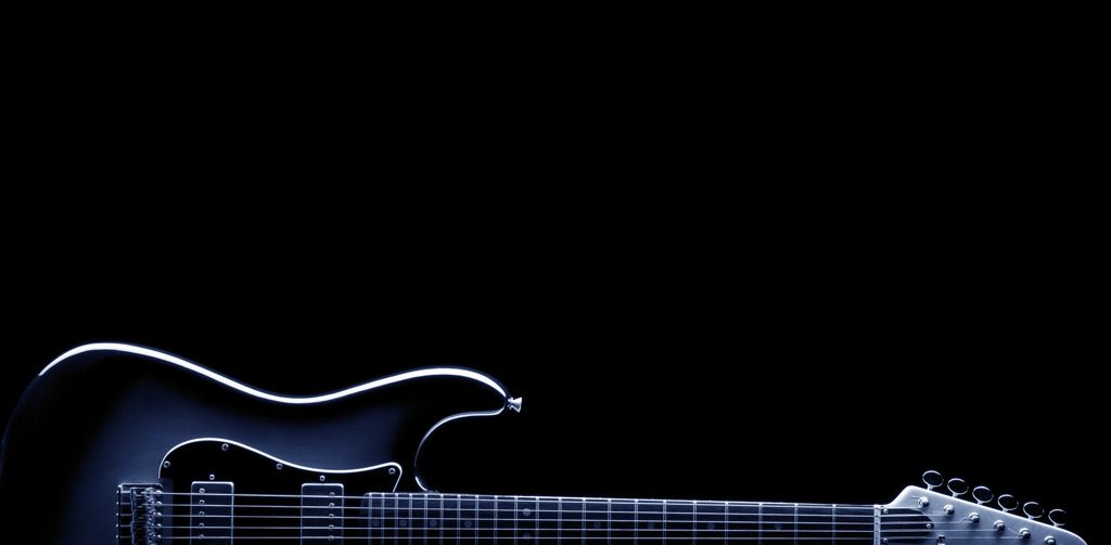 Glowing electric guitar body and neck lit against a dark background