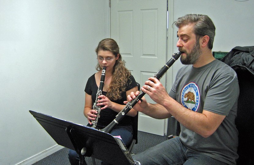 Male and female playing clarinet together