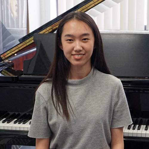 Michelle Wong in front of a grand piano after winning a university piano scholarship