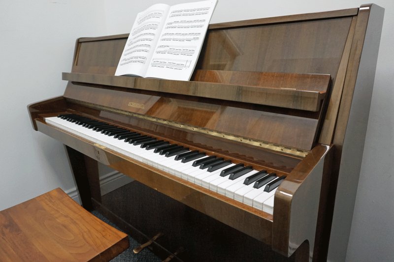 Schimmel upright piano with sheet music open in a Wandering Minstrel teaching room